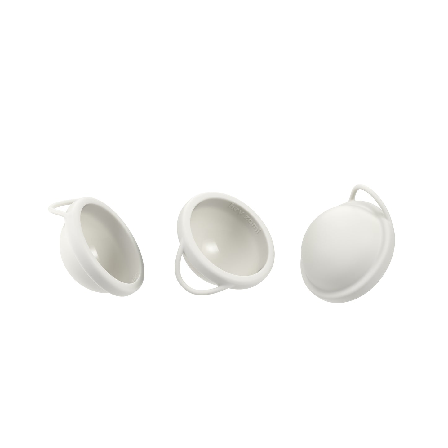Three white hey zomi menstrual discs on a white background
