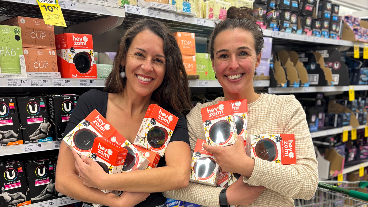 Hey Zomi is now in Woolworths - Mika and Zoe co-founders of Hey zomi in woolies with black menstrual discs on the shelf