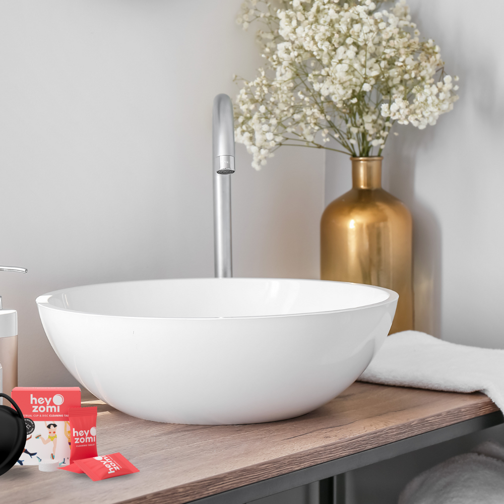 Hey Zomi Cleaning Tablets and reusable menstrual disc on a bathroom sink — easy, safe way to clean and sanitise your period disc without boiling.